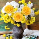 Still life with huge bunch of autumn flowers and roses, paints collection and wooden frame on painting background