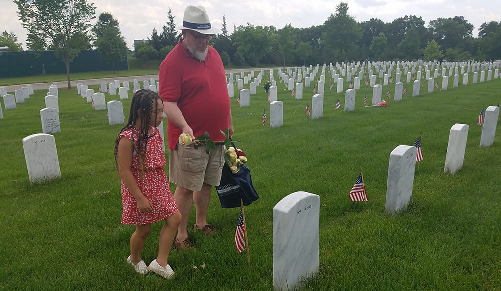 Gabrielle Miller and her father, Richard Miller, of Purcellville, Va., place flowers in section 54 at Arlington National Cemetery